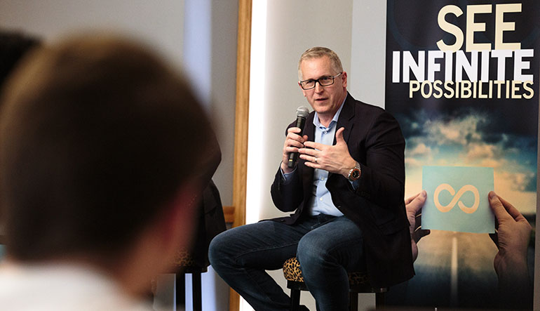 Bill Wagner '89 of LogMeIn sits in front of a Dyer Center banner while speaking with students